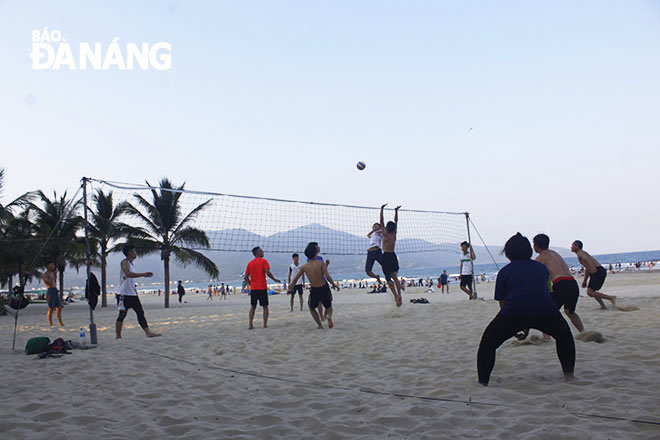 Young people playing beach volleyball