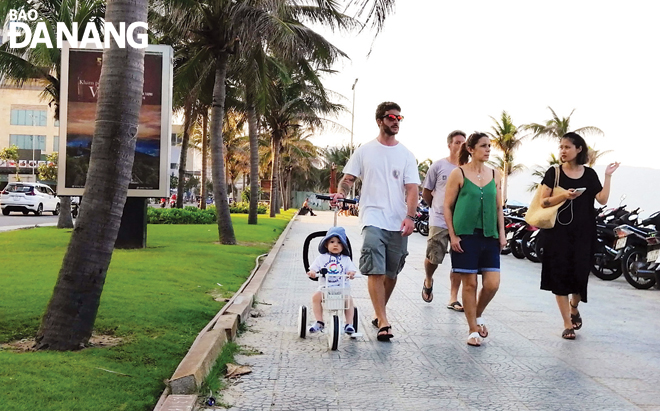 Foreigners going for stroll along beachside pavements of the coastal route