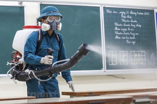 A worker fumigates a classroom of a Ha Noi school to prevent Covid-19 transmission (Photo: VNA)