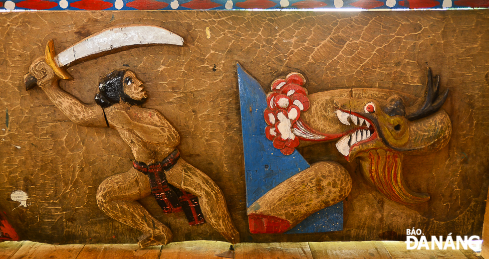 A carved image of a Co Tu warrior fighting against a sea monster