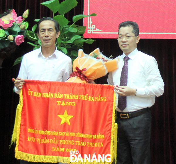 Phó Bí thư Thường trực Thành ủy Nguyễn Văn Quảng (phải) tặng Cờ Thi đua xuất sắc cho Đảng ủy Khu Công nghệ cao và các Khu Công nghiệp Đà Nẵng. Ảnh: LAM PHƯƠNG	