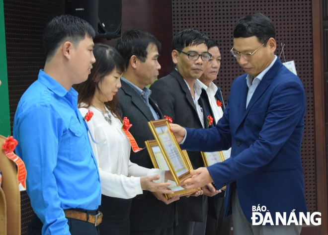 Phó Chủ tịch UBND thành phố Hồ Kỳ Minh (bên phải) tặng Bằng khen của UBND thành phố năm 2019 cho những tập thể, đơn vị làm tốt công tác giáo dục, cảm hóa thanh-thiếu niên sử dụng ma túy.                           Ảnh: T.S
