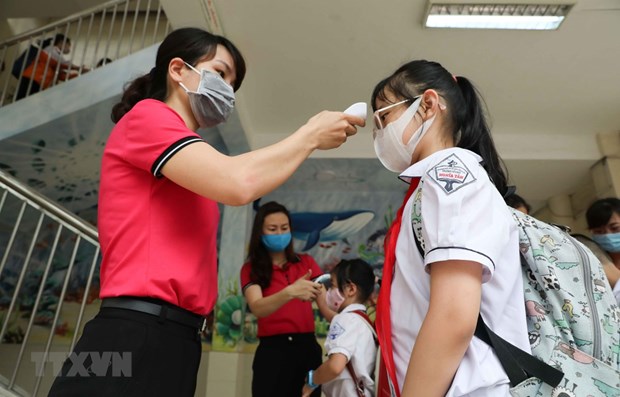 Measuring students' body temperature (Source: VNA)