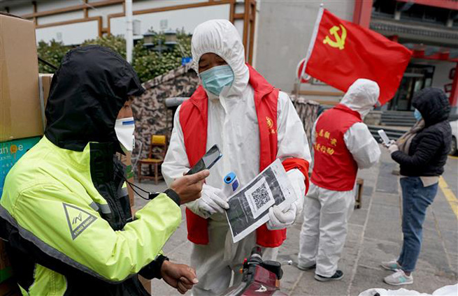 Người dân quét mã QR kiểm tra sức khỏe tại trạm kiểm soát ở Vũ Hán, tỉnh Hồ Bắc, Trung Quốc, ngày 11-4-2020. Ảnh: THX/TTXVN