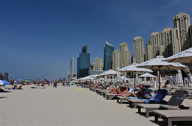 Người dân tắm nắng trên bãi biển ở Dubai, UAE, ngày 20-3-2020. Ảnh: AFP/TTXVN