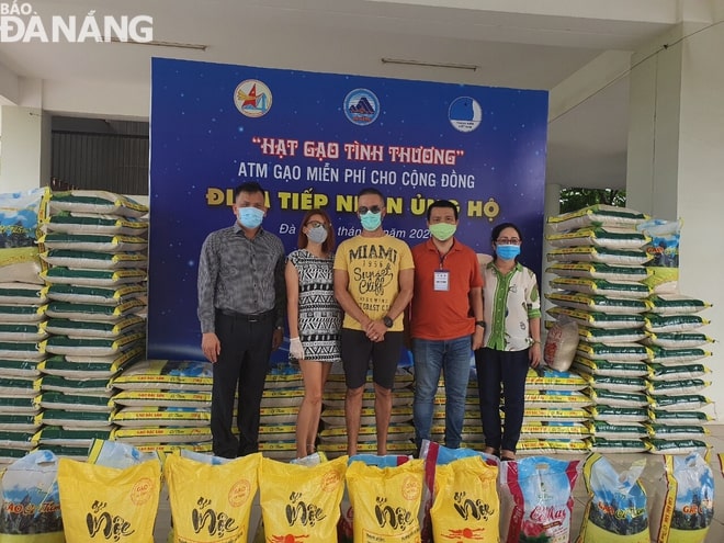 Foreigners (2nd and 3rd left) giving rice donations 