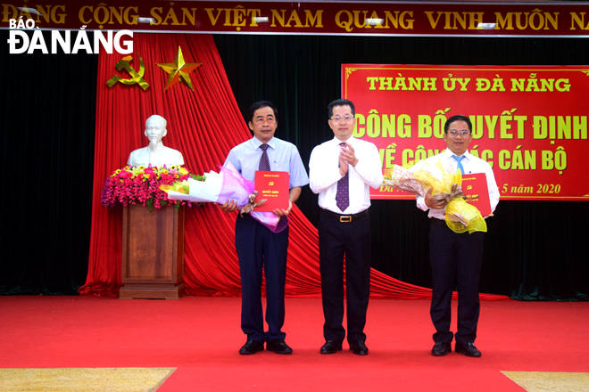 Phó Bí thư Thường trực Thành ủy Nguyễn Văn Quảng (giữa) trao quyết định và tặng hoa chúc mừng ông Phan Minh Hải (bên trái) và ông Hoàng Sơn Trà. Ảnh: TRỌNG HUY