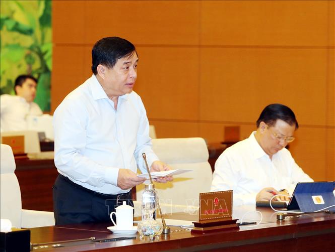 Bộ trưởng Bộ Kế hoạch và Đầu tư Nguyễn Chí Dũng trình bày báo cáo về kinh tế - xã hội. Ảnh: Trọng Đức/TTXVN