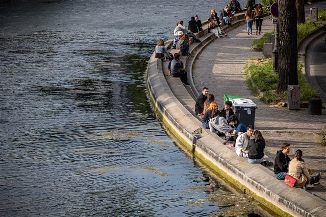 Người dân thư giãn bên dòng kênh Saint-Martin ở Paris, Pháp ngày 13-5-2020 khi nước này bắt đầu nới lỏng các hạn chế. Ảnh: AFP/TTXVN