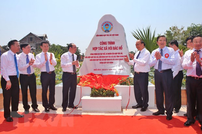 Thủ tướng Chính Phủ Nguyễn Xuân Phúc cùng các lãnh đạo gắn biển Công trình Hợp tác xã với Bác Hồ. (Ảnh: Danh Lam/TTXVN)