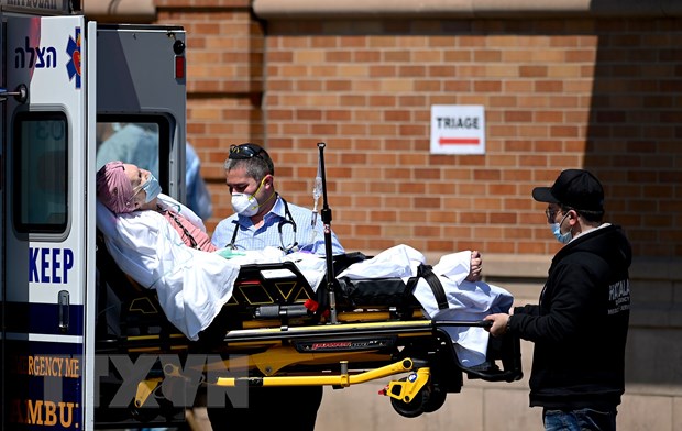 Nhân viên y tế chuyển bệnh nhân nghi mắc COVID-19 từ xe cứu thương vào một bệnh viện ở New York, Mỹ ngày 14/5/2020. (Ảnh: AFP/TTXVN)
