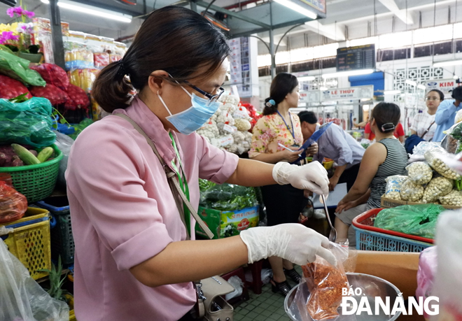 Lực lượng chức năng kiểm tra các mặt hàng kinh doanh thực phẩm tại chợ Hàn. Ảnh: PHAN CHUNG