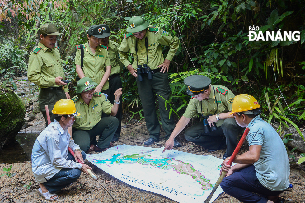 Forest rangers of the Ba Na-Nui Chua special use forest discussing with local residents about fire prevention and fighting activities