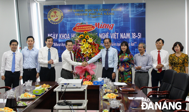 Phó Bí thư Thường trực Thành ủy Nguyễn Văn Quảng (thứ 4, trái sang) tặng hoa và chúc mừng Sở Khoa học và Công nghệ.  Ảnh: KHANG NINH