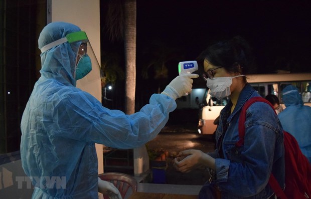 A woman has temperature checked (Photo: VNA)