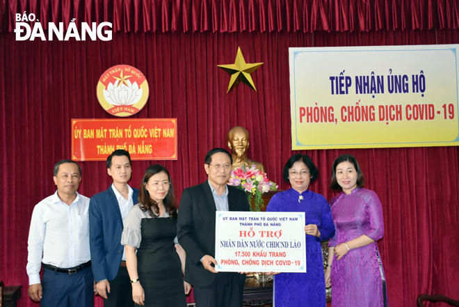 Chủ tịch Ủy ban MTTQ Việt Nam thành phố Đặng Thị Kim Liên (thứ 2 từ phải sang) trao quà cho đại diện Tổng Lãnh sự quán Lào.  Ảnh: Trần Khang