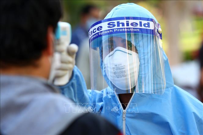 Nhân viên y tế kiểm tra thân nhiệt người dân nhằm ngăn chặn sự lây lan của dịch Covid-19 tại Giza, Ai Cập ngày 10-5. Ảnh: THX-TTXVN