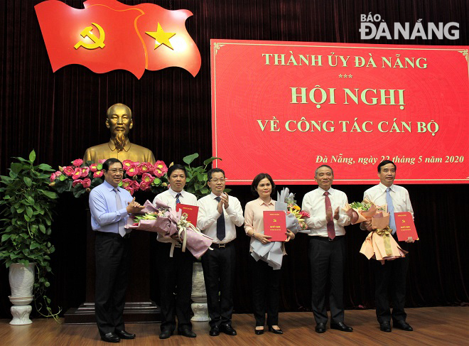 Bí thư Thành ủy Trương Quang Nghĩa (thứ 2, phải sang) trao các quyết định và tặng hoa chúc mừng các Ủy viên Ban Thường vụ Thành ủy, nhiệm kỳ 2015-2020. Ảnh: L.P