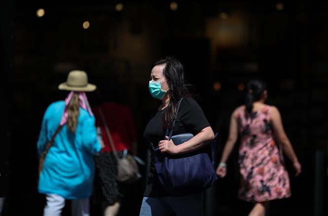  Người dân đeo khẩu trang phòng lây nhiễm COVID-19 tại Sydney, Australia, ngày 2/3/2020. Ảnh: THX/TTXVN