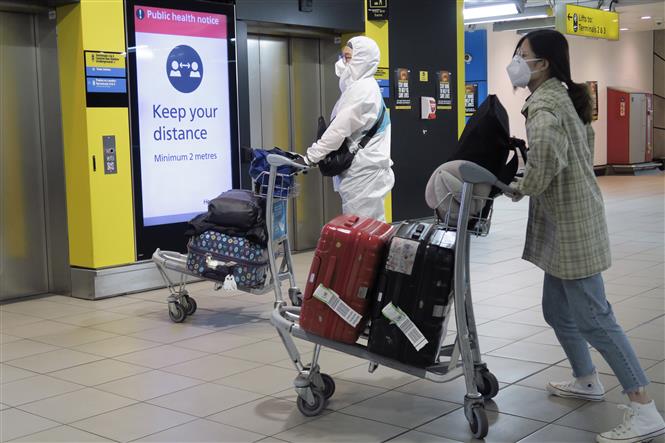  Hành khách đeo khẩu trang phòng lây nhiễm COVID-19 tại sân bay Heathrow ở London, Anh, ngày 1/5/2020. Ảnh: THX/TTXVN
