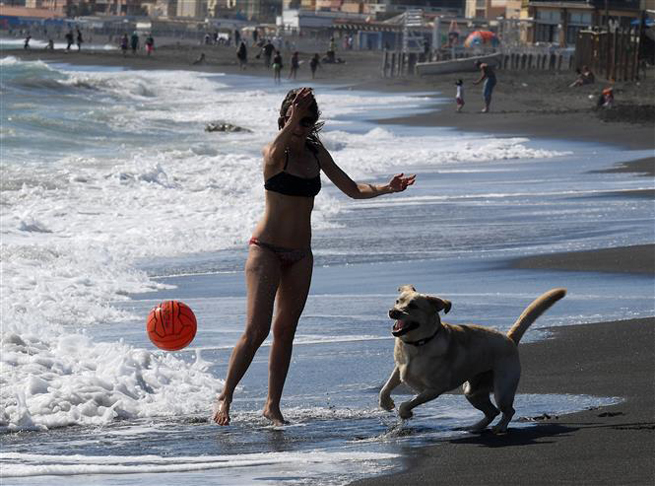  Người dân chơi đùa trên bãi biển tại Ladispoli, gần Rome, Italy ngày 24-5-2020. Ảnh: THX/ TTXVN