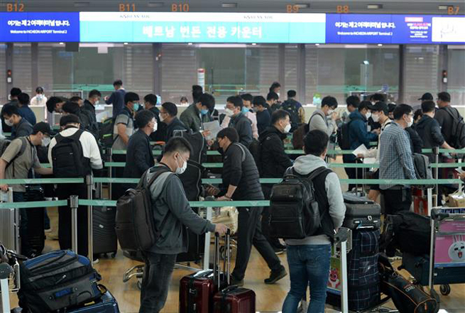  Hành khách chờ đợi tại quầy làm thủ tục ở sân bay Incheon, Hàn Quốc ngày 29-4-2020. Ảnh: Yonhap/ TTXVN