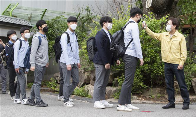   Kiểm tra thân nhiệt cho học sinh tại một trường trung học ở Seoul, Hàn Quốc ngày 20-5-2020. Ảnh: THX/ TTXVN