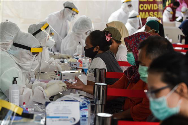  Nhân viên y tế lấy mẫu xét nghiệm Covid-19 cho người dân tại Nam Tangerang, Indonesia ngày 14-5-2020. Ảnh: THX/TTXVN