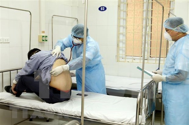 A doctor examines a Covid-19 patient (Photo: VNA) 