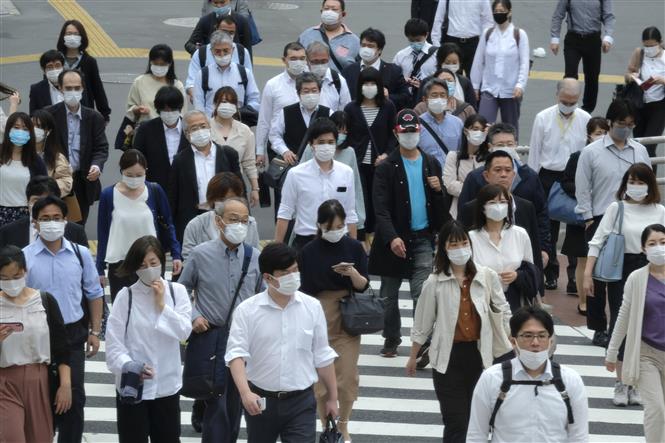  Người dân đeo khẩu trang phòng dịch COVID-19 khi di chuyển trên phố ở Tokyo, Nhật Bản ngày 26/5/2020. Ảnh: AFP/TTXVN