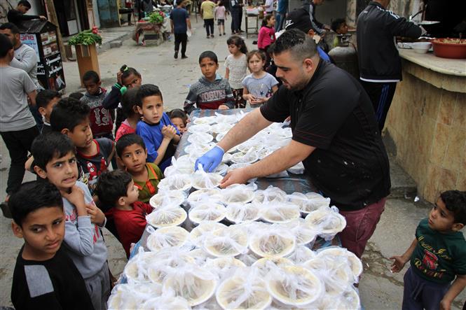   Người Palestine phân phát thức ăn miễn phí nhân tháng lễ Ramadan ở Deir al-Balah, miền Trung Dải Gaza ngày 27/4/2020. Ảnh: THX/TTXVN
