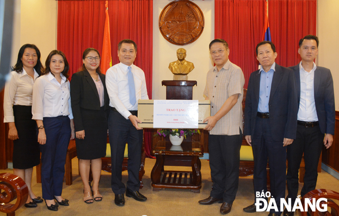 Representatives from the Da Nang Union of Friendship Organisations and the city branch of the Viet Nam-Laos Friendship Association handing reusable antibacterial face masks to staff of the Laos Consul General in Da Nang 