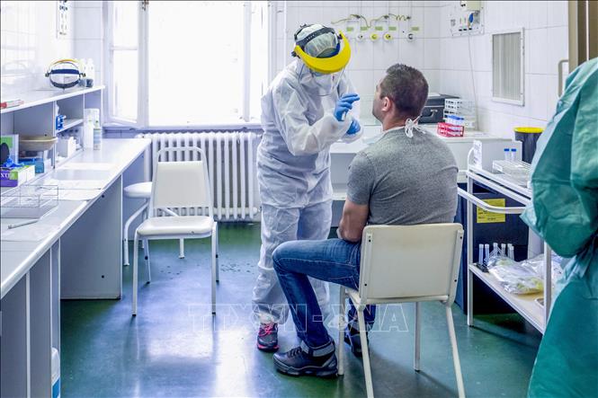Nhân viên y tế lấy mẫu dịch xét nghiệm Covid-19 tại trung tâm y tế ở Budapest, Hungary ngày 27-3. Ảnh: AFP/TTXVN