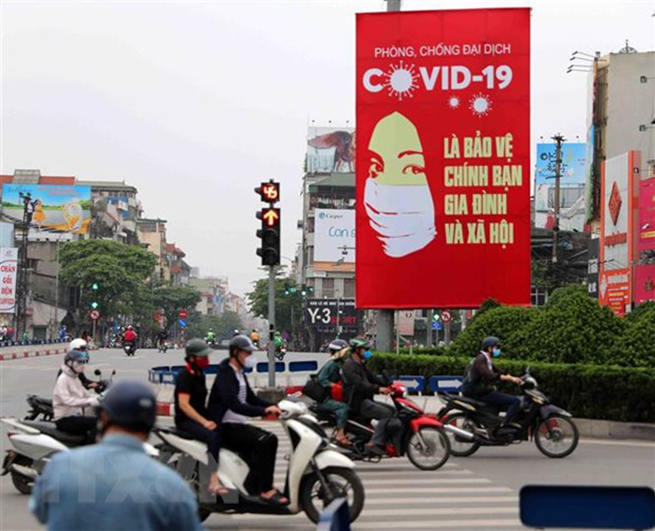 Tranh tuyên truyền về Covid-19 được đặt ở các điểm nút giao thông của Hà Nội. (Ảnh: Thanh Tùng/TTXVN)