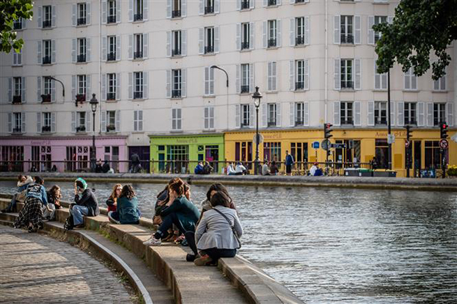  Người dân thư giãn bên sông Saint-Martin ở Paris, Pháp khi lệnh phong tỏa được nới lỏng, ngày 13-5-2020. Ảnh: THX/TTXVN