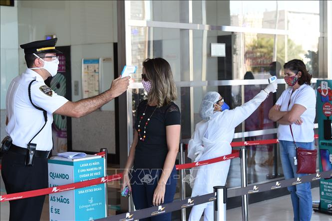 Kiểm tra thân nhiệt phòng lây nhiễm COVID-19 trước khi vào trung tâm thương mại ở Brasilia, Brazil. Ảnh: AFP/TTXVN