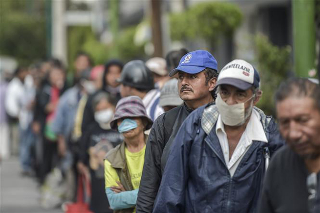 Người vô gia cư xếp hàng chờ nhận lương thực cứu trợ bên ngoài một bệnh viện ở Mexico City, Mexico ngày 9-5-2020. Ảnh: AFP/TTXVN