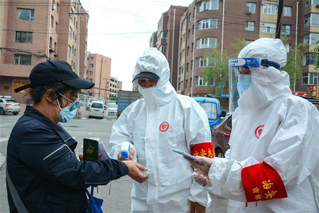 Các tình nguyện viên mặc trang phục bảo hộ kiểm tra thân nhiệt người dân tại tỉnh Cát Lâm, Trung Quốc ngày 25-5-2020. Ảnh: AFP/TTXVN