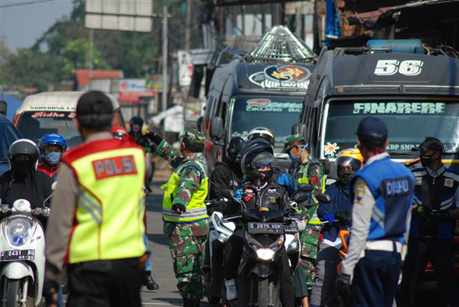 Cảnh sát Indonesia kiểm tra các phương tiện tại một trạm kiểm soát ở Sumedang, tỉnh Tây Java nhằm ngăn chặn sự lây lan của dịch Covid-19 ngày 10-5-2020. Ảnh: AFP/TTXVN