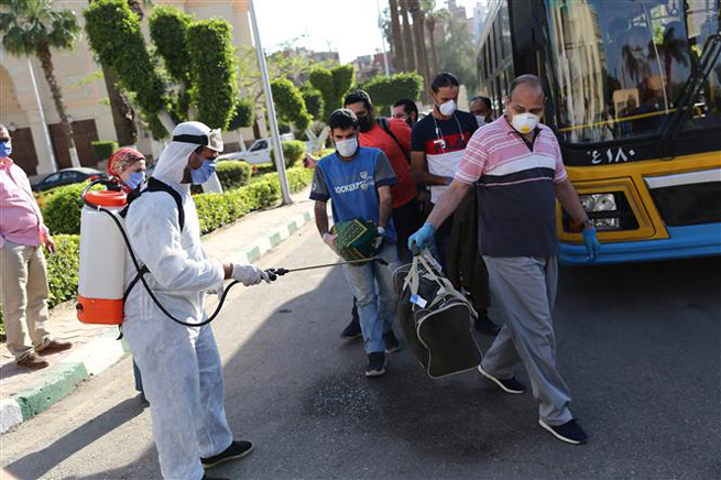 Nhân viên y tế phun thuốc khử trùng nhằm ngăn chặn sự lây lan của dịch Covid-19 tại Giza, Ai Cập. Ảnh: THX/TTXVN