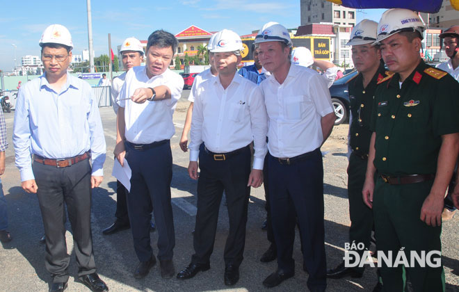 Phó Bí thư Thường trực Nguyễn Văn Quảng (người thứ 3 từ trái sang) đang nghe Ban Quản lý dự án báo cáo công tác thi công công trình. Ảnh: THÀNH LÂN