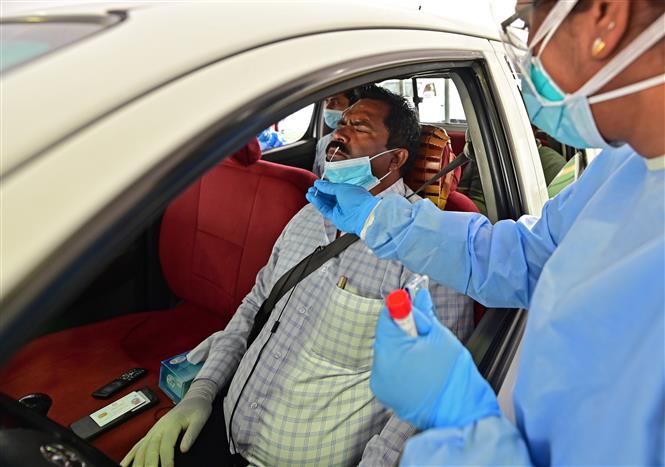 Nhân viên y tế lấy mẫu dịch xét nghiệm COVID-19 cho người dân tại Abu Dhabi, UAE ngày 2/4/2020. Ảnh: AFP/ TTXVN