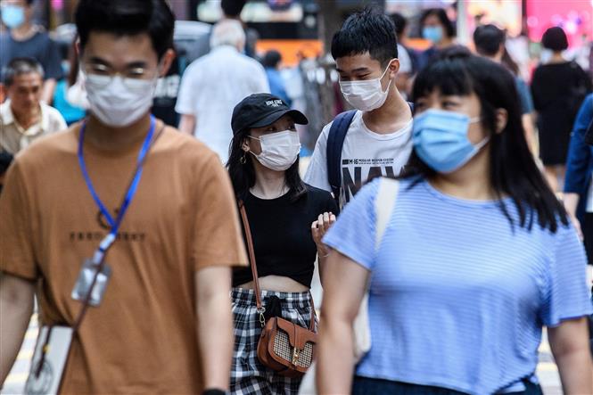 Người dân đeo khẩu trang phòng dịch COVID-19 tại Hong Kong, Trung Quốc ngày 13/5/2020. Ảnh: AFP/TTXVN