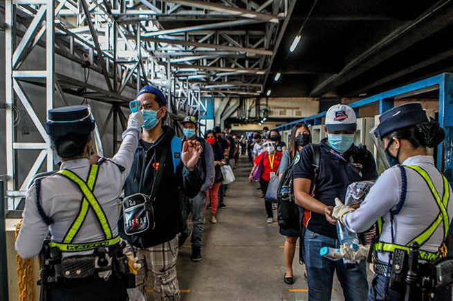Kiểm tra thân nhiệt cho hành khách lên tàu hỏa tại Manila, Philippines ngày 1-6-2020. Ảnh: THX/ TTXVNảnh
