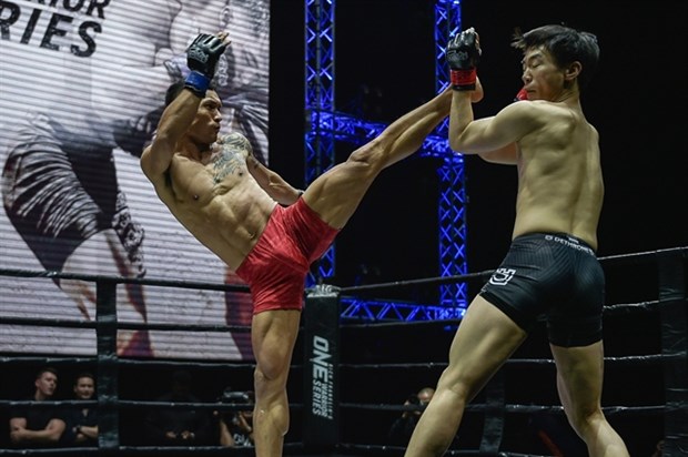 Vienamese leading MMA fighter Tran Quang Loc (left) lands a kick on Kim Jong Heon during their ONE Warrior Series match last February in Singapore (Photo: zing.vn)