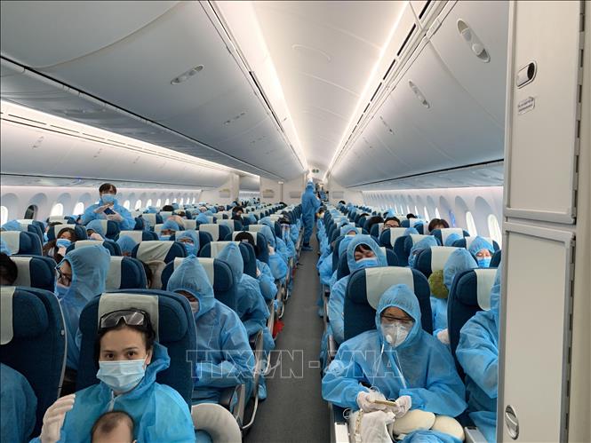 Tất cả hành khách được phát và phải mặc đồ bảo hộ trong suốt chuyến bay từ Vương quốc Anh về Việt Nam. Ảnh: TTXVN phát