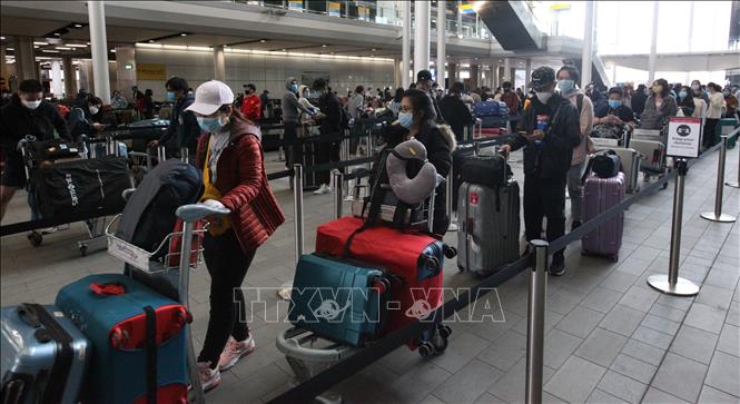 Công dân Việt Nam xếp hàng chờ làm thủ tục lên máy bay của Vietnam Airlines tại sân bay Heathrow, London, Vương quốc Anh. Ảnh: Đình Thư/TTXVN