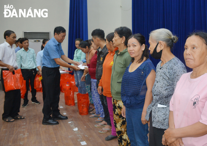 Ông Lê Định, đại diện Công ty CP Tập đoàn T&T Group, trao quà và tiền hỗ trợ người nghèo ở huyện Hòa Vang. Ảnh: LÊ VĂN THƠM