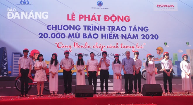 Nguyen Hien Senior High School pupils receiving helmets from a representative from Honda Vietnam Company