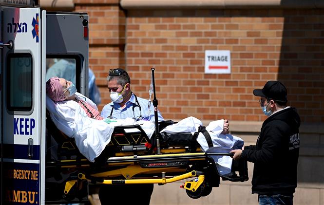Nhân viên y tế chuyển bệnh nhân mắc COVID-19 vào một bệnh viện ở New York, Mỹ ngày 14/5/2020. Ảnh: AFP/TTXVN